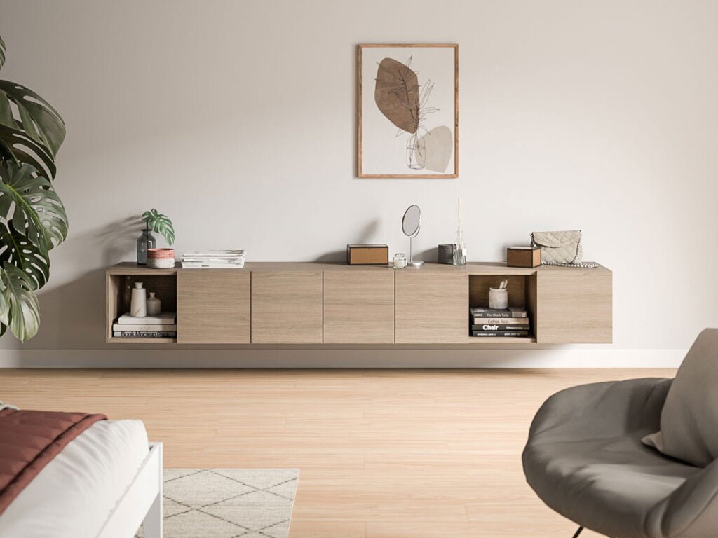 Ein wandgehängtes Sideboard mit sieben Segmenten, davon zwei offen und fünf mit geschlossenen Drehtüren. Das Sideboard ist einheitlich aus aschfarbenem Holzdekor gearbeitet. Es hängt an einer leicht abgetönten weiß gestrichenen Wand und ist mit verschiedenen Utensilien, wie ein Schminkspiegel, einer Handtasche, einem Raumduft, einer Vase und Zeitschriftenstapel dekoriert. An den Bildrändern deuten eine Grünpflanze, ein angeschnittenes Bett und ein angeschnittener Stuhl auf ein Jugendzimmer hin.