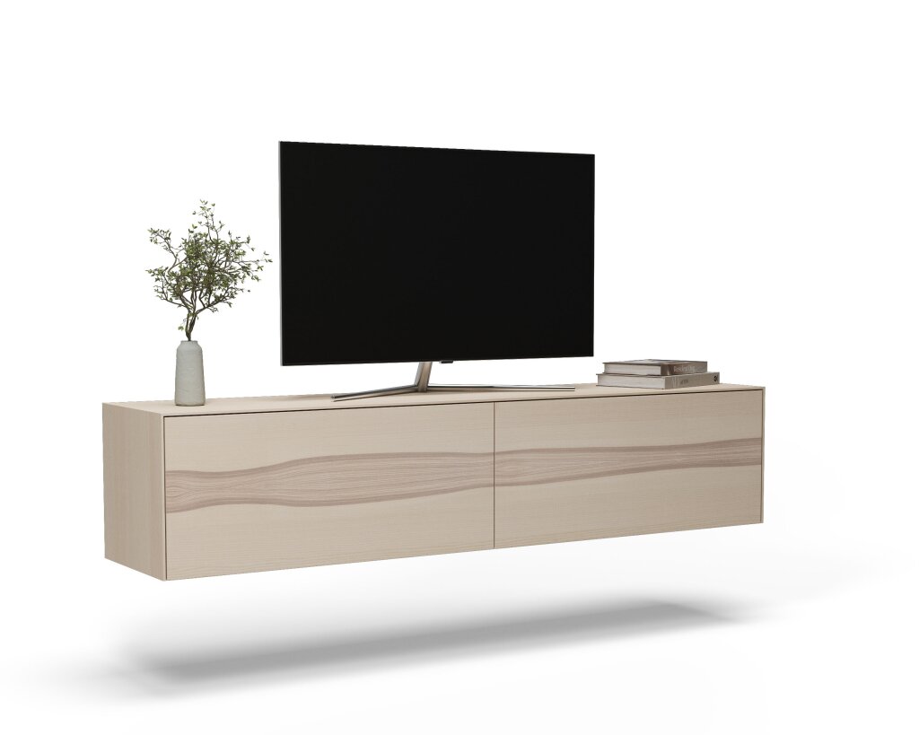 Ein schwebendes Sideboard aus Esche massiv mit lebendigem Kerneschefurnier an der Möbelfront. Auf dem Möbel steht ein TV - Bildschirm, ein kleiner Bücherstapel und eine Vase.